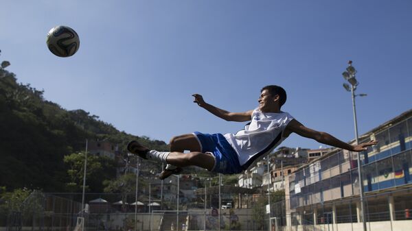 Мальчик играет в футбол в трущобах Vidigal Рио-де-Жанейро, Бразилия. 17 июня 2014 год