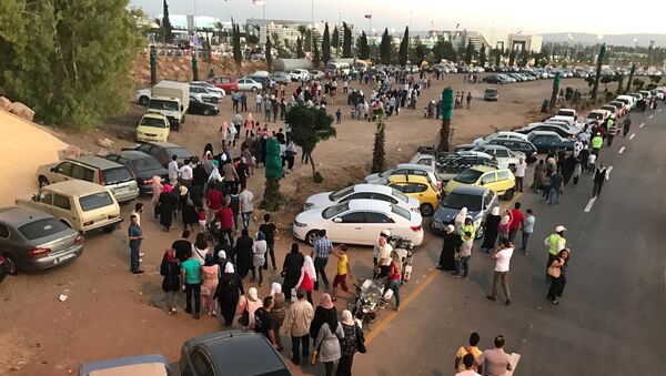 Посетители у входа в выставочный городок на южной окраине Дамаска, где впервые с начала вооруженного конфликта в Сирии открылась 59-я Международная промышленная выставка. 19 августа 2017