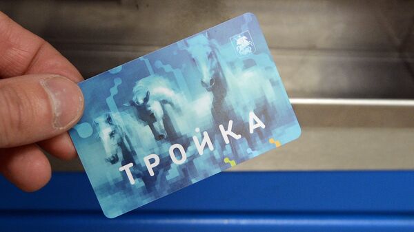 Мужчина демонстрирует билет Тройка на станции Московского метрополитена.