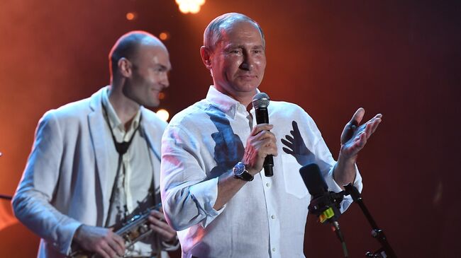 Президент РФ Владимир Путин во время посещения фестиваля Koktebel Jazz Party 2017. Слева - музыкант-саксофонист Сергей Головня