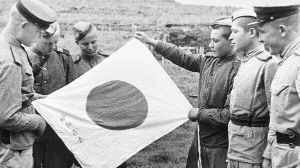 Советские воины рассматривают брошенный при отступлении японский флаг