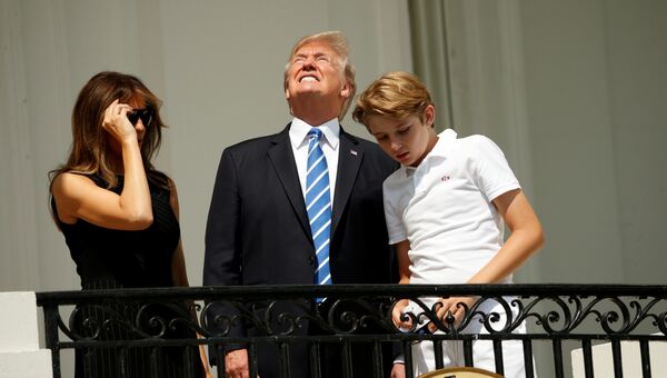 Дональд Трамп смотрит на солнечное затмение с балкона Белого дома