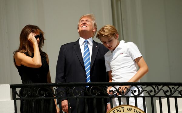 Президент США Дональд Трамп с семьей наблюдают за солнечным затмением с балкона Белого дома. 21 августа 2017