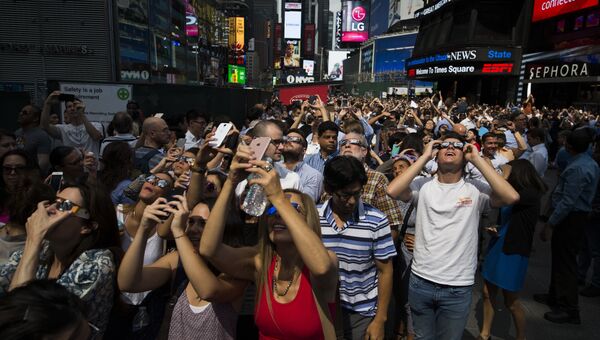 Люди наблюдают за солнечным затмением в Нью-Йорке. 21 августа 2017