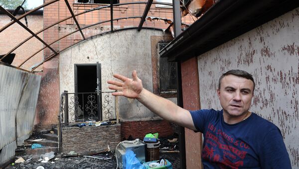 Местный житель показывает свой дом, пострадавший в результате пожара, в Ростове-на-Дону. 22 августа 2017