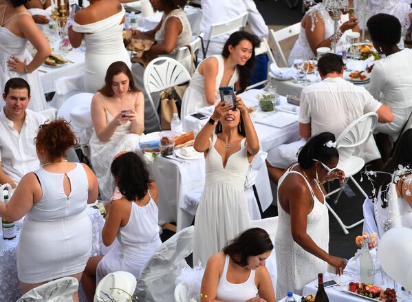 Участники ежегодного ужина в белых одеяниях в Нью-Йорке