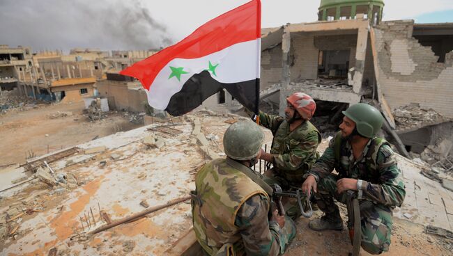 Сирийские военнослужащие с флагом