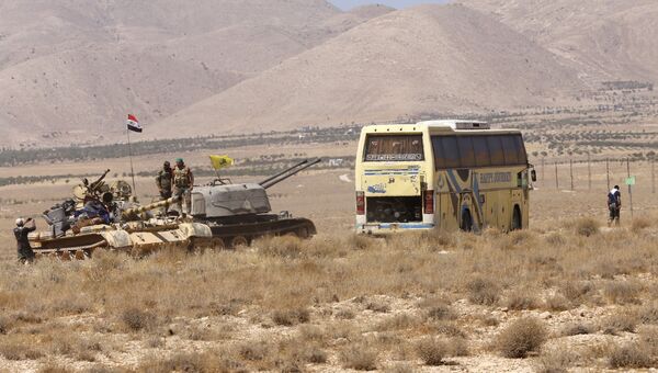 Сирийские военные и автобус с боевиками ИГ (группировка Исламское государство, запрещена в РФ) в районе Западного Каламуна