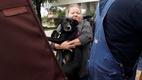 Женщина, пострадавшая от шторма Харви, и её собака во время эвакуации из города Дикинсон, Техас. 27 августа 2017