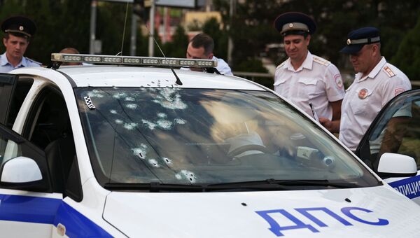 Сотрудники правоохранительных органов у автомобиля ДПС, обстрелянного злоумышленником в Краснодаре