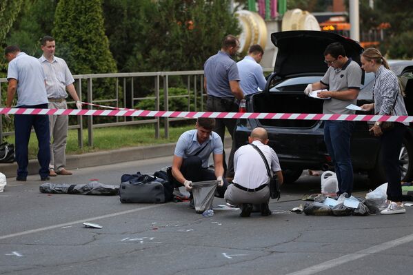 Сотрудники правоохранительных органов у автомобиля злоумышленника, ранившего сотрудника полиции на посту ДПС в Краснодаре