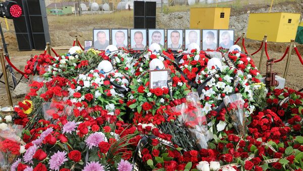 Цветы и свечи у памятного камня рядом со зданием администрации рудника Мир. 29 августа 2017