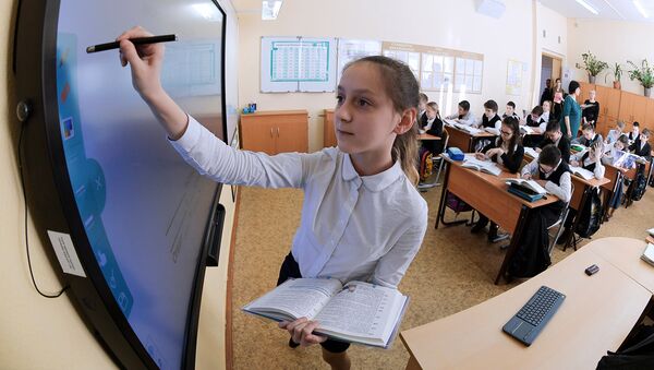 Ученица выполняет задание возле интерактивной доски во время урока в московской школе. Архивное фото