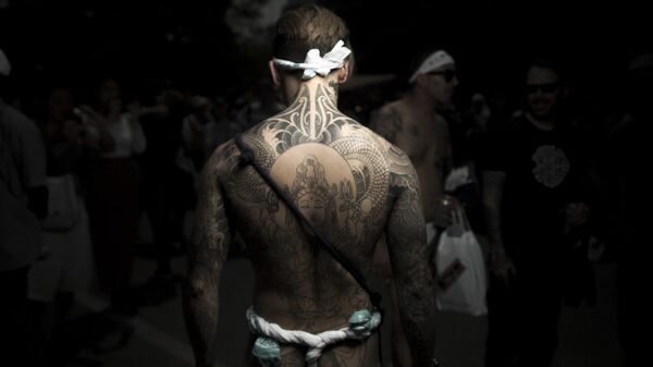 Мужчина с традиционной японской татуировкой Ирезуми на фестивале Сандзя-мацури в Токио