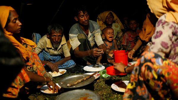 Люди из народности рохинджа обедают во временном лагере  в Кокс-Базаре, Бангладеш