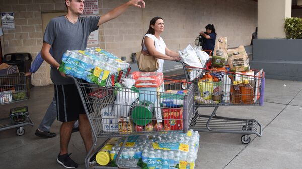  Покупатели склада-магазина Костко закупают воду, готовясь к приходу урагана Ирма в Майами, США. 5 сентября 2017