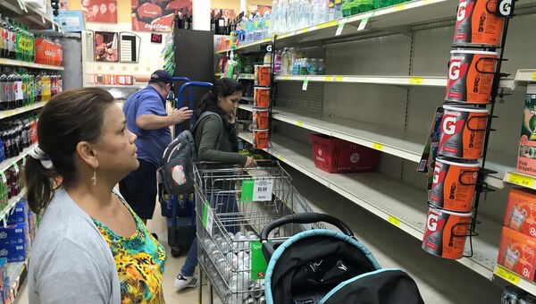 Покупатели перед пустыми полками с водой в магазине в МАйаме, США. 5 сентября 2017