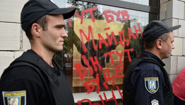 Сотрудники полиции у разбитых витрин магазина на улице Грушевского в Киеве