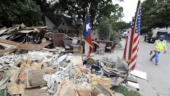 Рабочий у завалов, образовавшихся после урагана Харви в городе Спринг, Техас, США. 5 сентября 2017