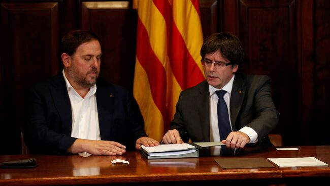 Председатель правительства Каталонии Карлес Пучдемон и вице-президент Уриол Жункерас подписывают декрет о проведении референдума о независимости от Испании. Архивное фото