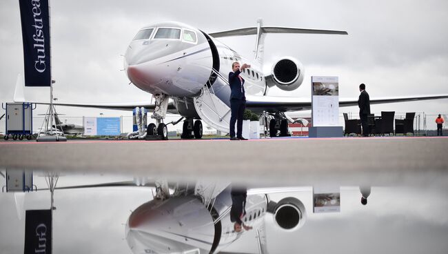 Посетитель у самолета Gulfstream G650ER на международной выставке деловой авиации JetExpo 2017