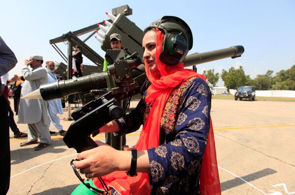 Женщина держит оружие во время празднования Дня обороны, на авиабазе Нур хан в Исламабаде, Пакистан