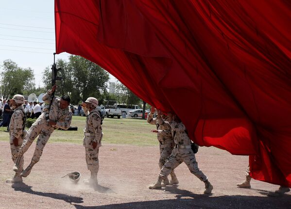 Солдат случайно зацепился винтовкой за национальный флаг во время подготовки к 207-й годовщине независимости Мексики в Сьюдад-Хуаресе, Мексика