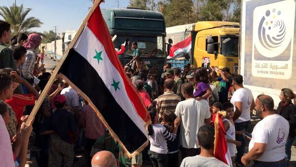 Жители сирийского города встречают автоколонну с гуманитарной помощью. Архивное фото