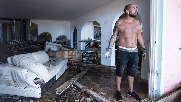 Мужчина посреди дома, разрушенного ураганом Ирма, на на острове Сен-Мартен в Карибском море. 7 сентября 2017