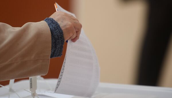Избиратель кидает бюллетень в урну в единый день голосования на избирательном участке. 10 сентября 2017