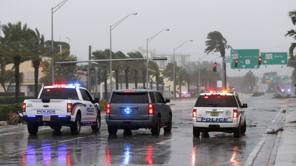 Полицейские машины на дороге в Санни-Айлс-Бич во Флориде среди разрушений вызванных ураганом Ирма. 9 сентября 2017