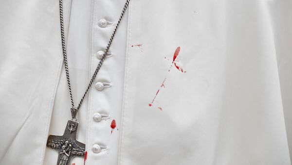Кровь на тунике Папы Римского Франциска после удара о металлическую перегородку папамобиля. 10 сентября 2017