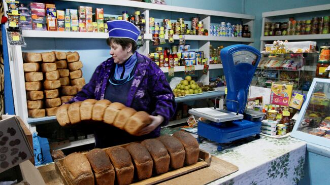 Продавец принимает свежий хлеб в сельском магазине