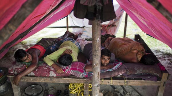Рабочие отдыхают в палатке возле завода по переработке алюминия на окраине Дакки, Бангладеш