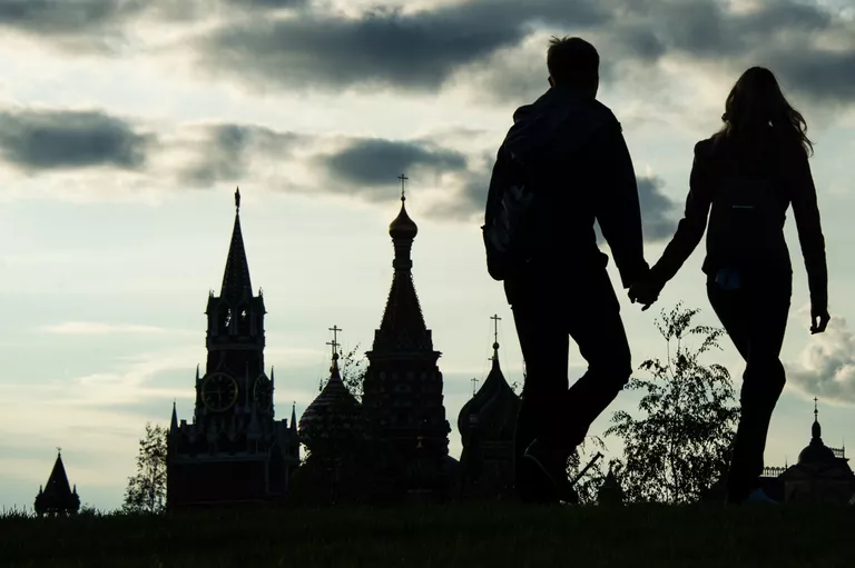 Москвичи на фоне Спасской башни Московского Кремля Москвичи на фоне Спасской башни Московского Кремля