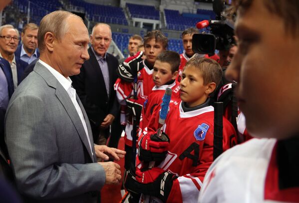 Президент РФ Владимир Путин вместе с хоккеистами сборных СССР и Канады, участвовавших в легендарной суперсерии 1972 года, общается с молодыми хоккеистами