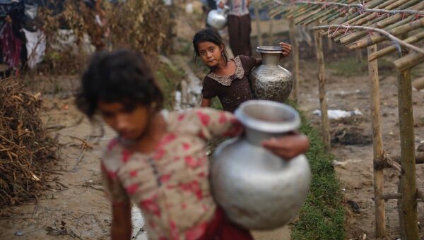 Девочки из семей беженцев-рохинджа c кувшинами с водой в Бангладеш