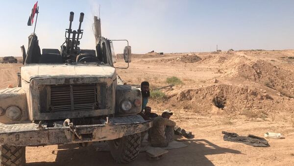 Бойцы сирийской армии отдыхают в тени техники на позициях в районе Дейр-эс-Зора. 15 сентября 2017