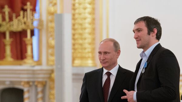 Президент России Владимир Путин (слева) и нападающий сборной по хоккею Александр Овечкин на церемонии награждения национальной сборной