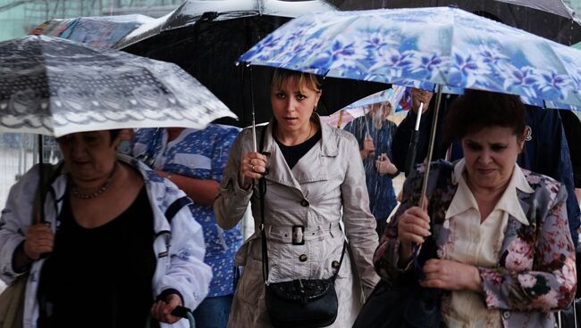 Прохожие во время ливня на одной из улиц Москвы. Архивное фото