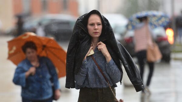 Прохожие идут на Смоленской площади во время дождя в Москве. Архивное фото