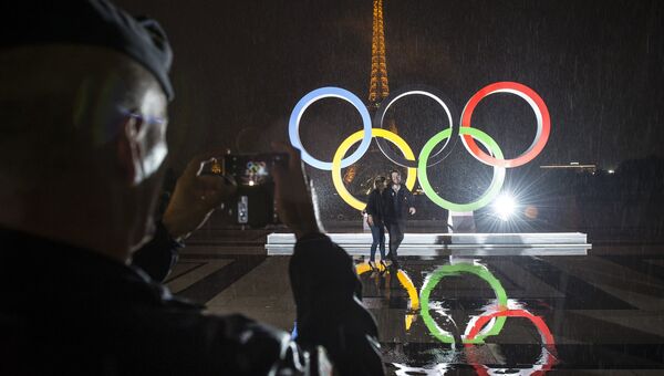 Туристы фотографируются на фоне Олимпийских Колец в Париже