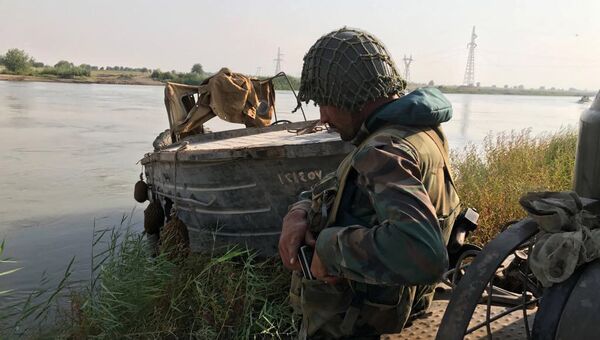 Боец сирийской армии во время подготовки к форсированию реки Ефрат в районе города Дейр-эз-Зор. 18 сентября 2017