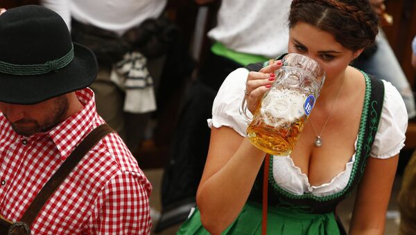 Гостья фестиваля пьет пиво на открытии Октоберфест в Мюнхене