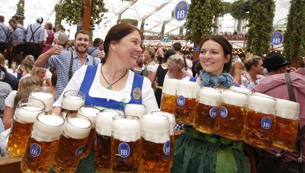 Официантки несут кружки с пивом на открытии фестиваля Октоберфест в Мюнхене