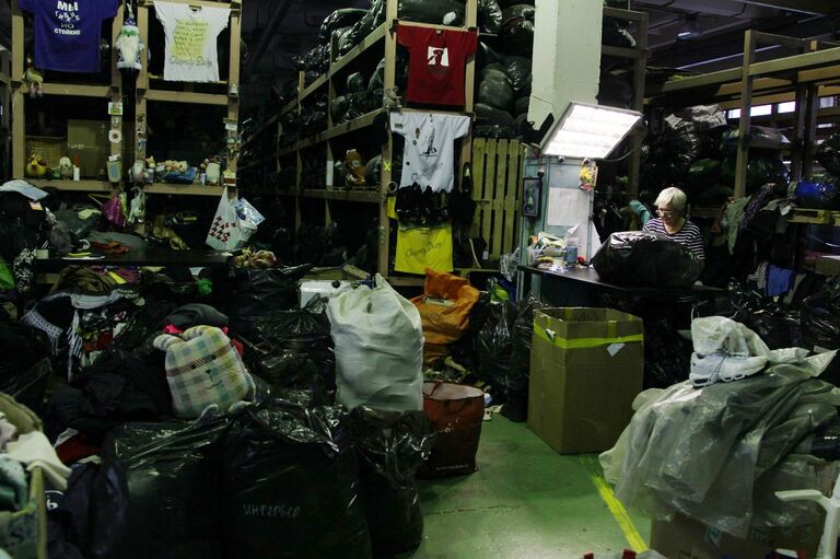 Сортировка вещей, сданных в благотворительные контейнеры Charity Shop Сортировка вещей, сданных в благотворительные контейнеры Charity Shop