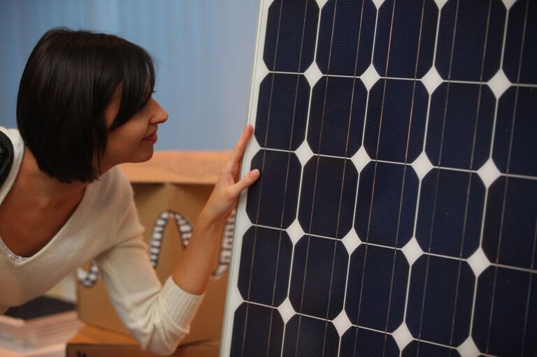 Девушка рассматривает солнечную панель