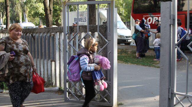 Женщина с ребенком у здания Республиканской клинической больницы в Донецке перед отправкой на лечение в Россию. 19 сентября 2017