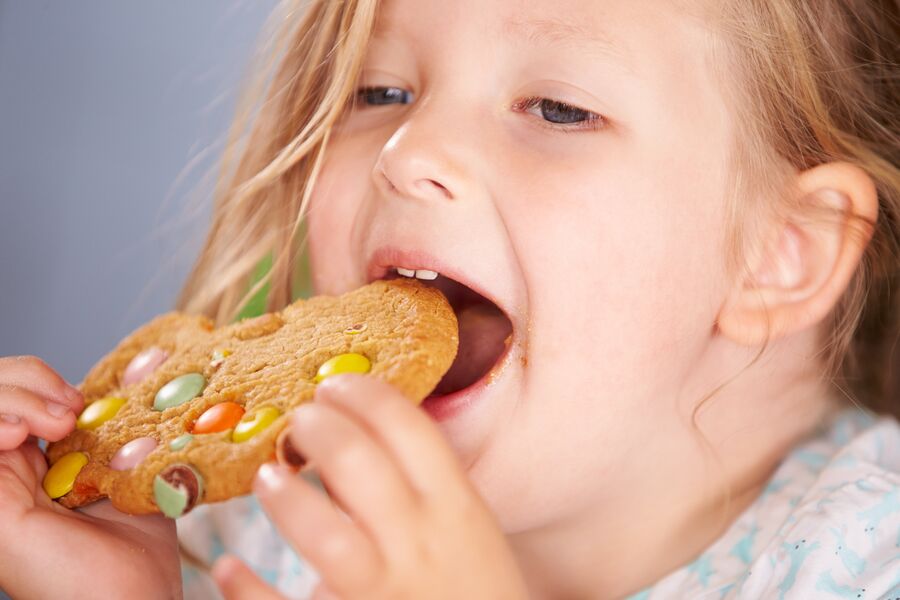 Девочка ест печенье
