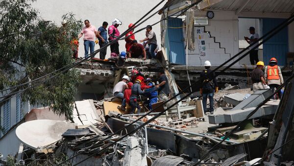 Люди помогают пострадавшим во время землетрясения в Мехико